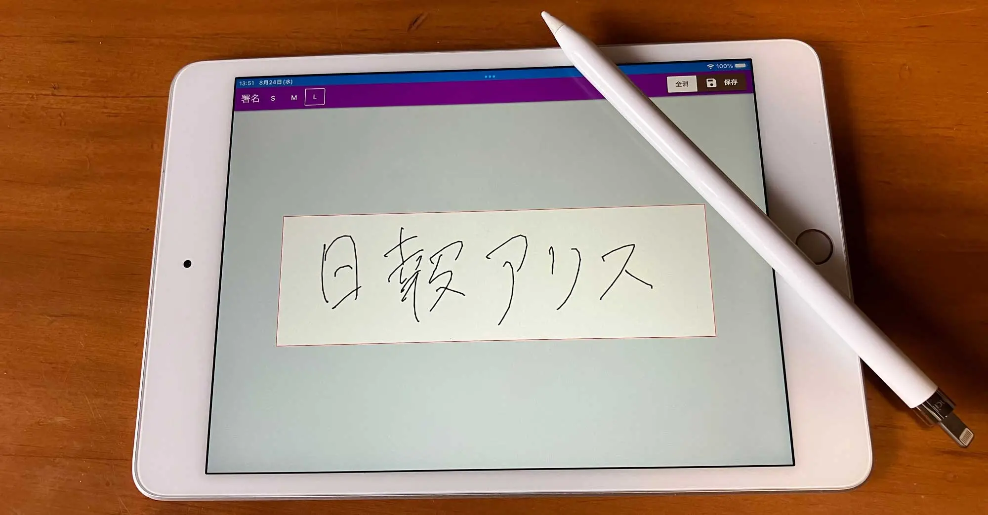 iPad miniとApple Pencilを使って手書きの署名をタブレットに書き込んでいる様子